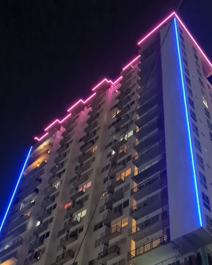 Torre de departamentos de noche con tira LED rosa y azul